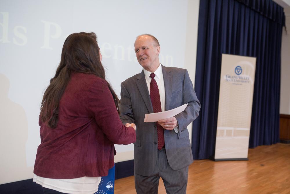 3MT People's Choice winner Chelse Hawkings shaking hands with the dean of the graduate school